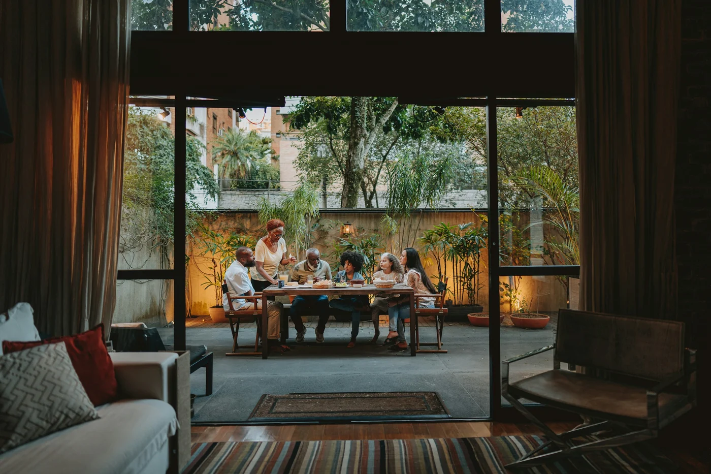 Friends sharing a meal on a sunlit terrace.